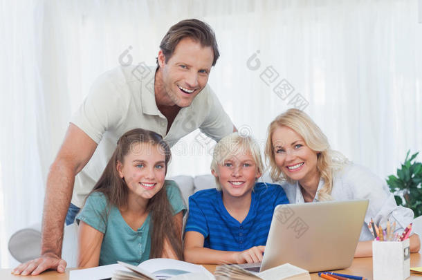 微笑的一<strong>家人一起</strong>用笔记本做家庭作业