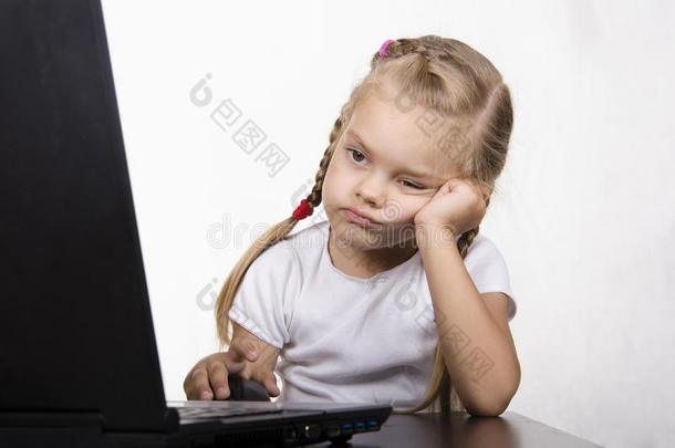 坐在桌边运行笔记本电脑的女孩