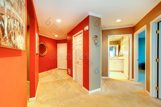 城市公寓的大<strong>型红色</strong>走廊，带开放式浴室<strong>门</strong>和米色地毯。