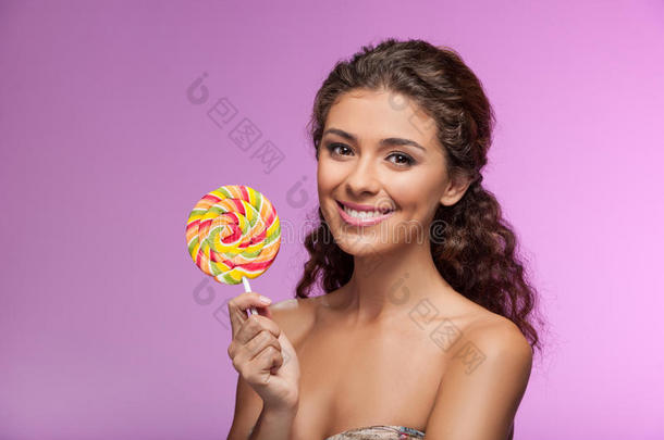 棒棒糖的美丽。 漂亮的年轻女人拿着棒棒糖