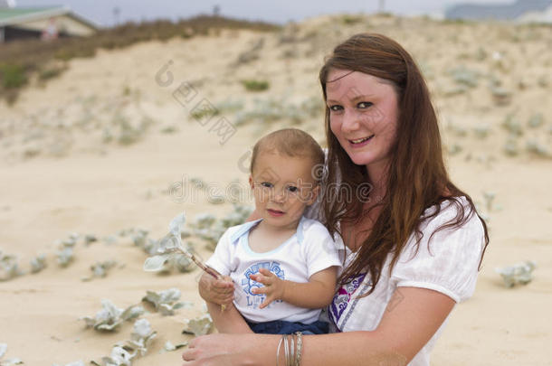 妈妈和宝宝在沙滩上，微笑的妈妈