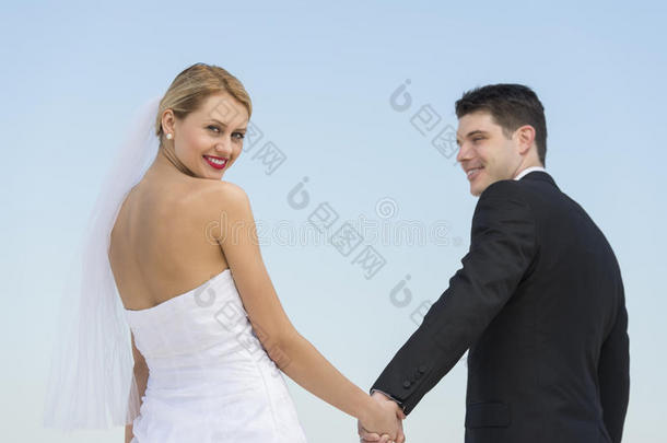 新娘牵着新郎的手顶着湛蓝的天空