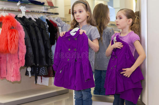 两个可爱的小女孩在镜子旁边试穿衣服