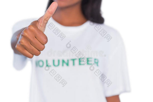 一位女士穿着志愿者T恤，竖起大拇指