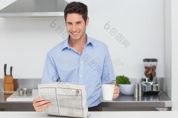 一个人看报纸，端着一杯咖啡