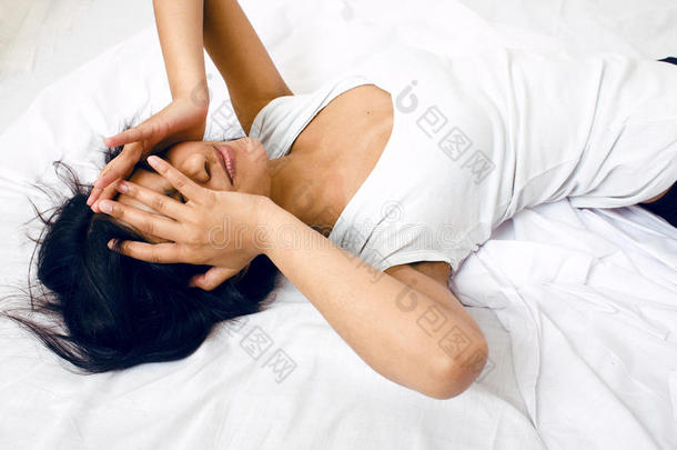 漂亮的黑发女人躺在床上，睡不着觉
