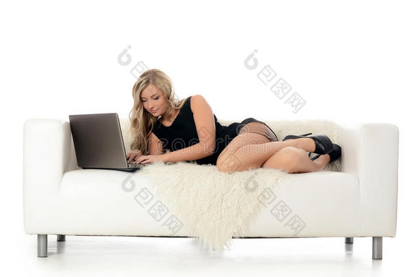 坐在<strong>白色沙发</strong>上拿着笔记本电脑的优雅女人。商业理念。