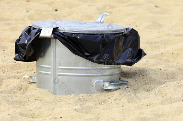 海滩上的灰色金属垃圾桶或垃圾桶