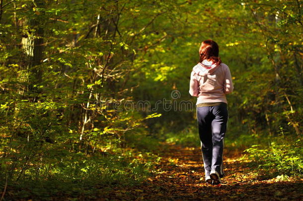 秋林中走越野小道的女子