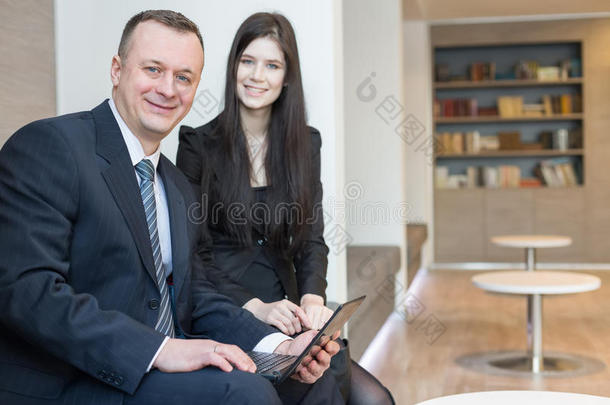 微笑的男人和女人<strong>坐在</strong>笔记本<strong>电脑前</strong>