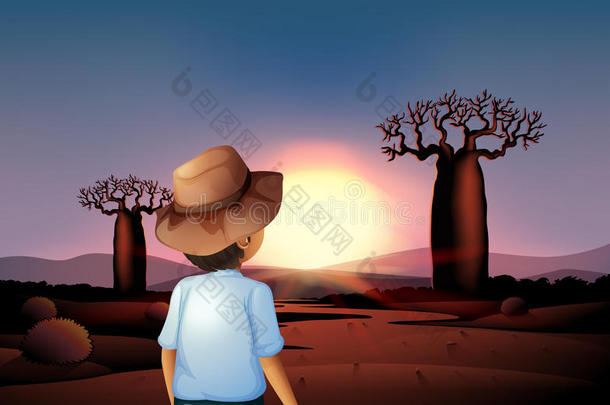 戴帽子<strong>的</strong>男孩在<strong>沙漠里</strong>看日落
