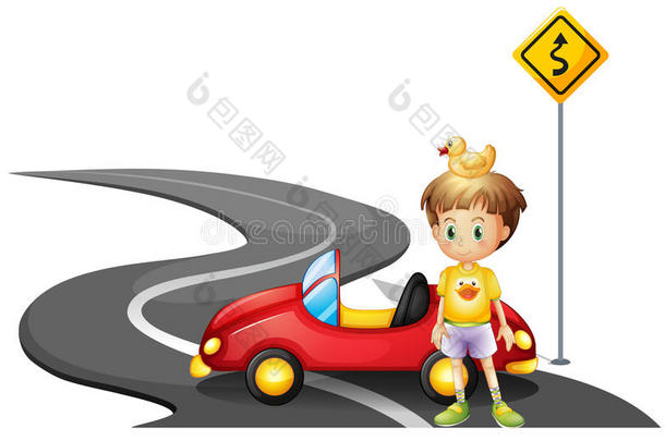 一个小男孩和他的车在靠近黄色招牌的路上