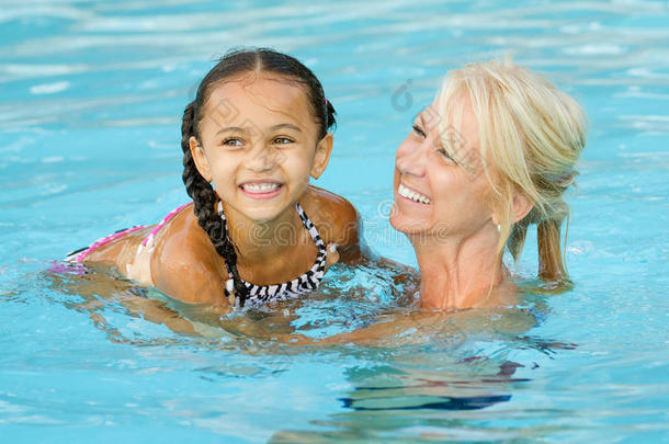 母亲和混血女孩在游<strong>泳池里玩耍</strong>