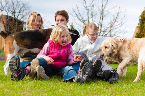 一家人和狗一起坐在草地上
