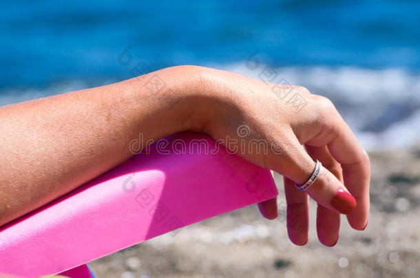 女人在躺椅上放松，沙滩上，面朝大海