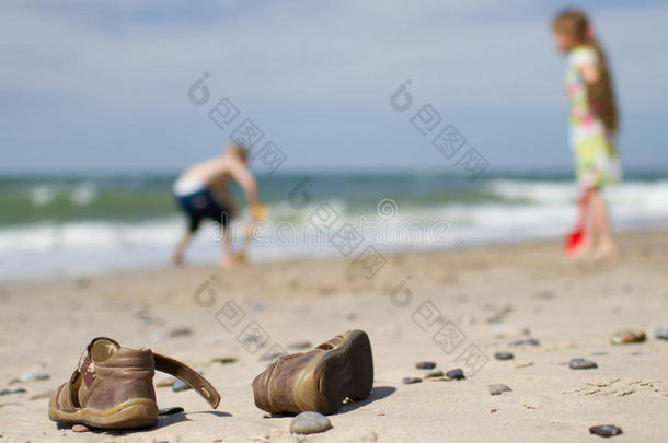 儿童凉鞋和沙滩上的儿童