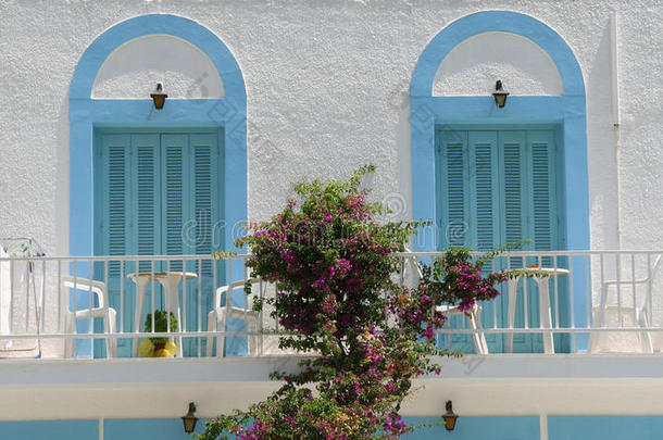 带蓝色百叶窗和三角梅的传统希腊阳台