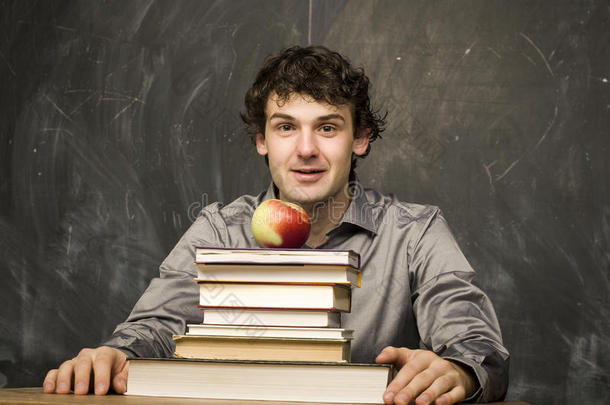 情绪化<strong>的学生在教室里</strong>，黑板上拿着书和红苹果