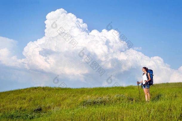 背着背包、拿着登山杖的年轻女子