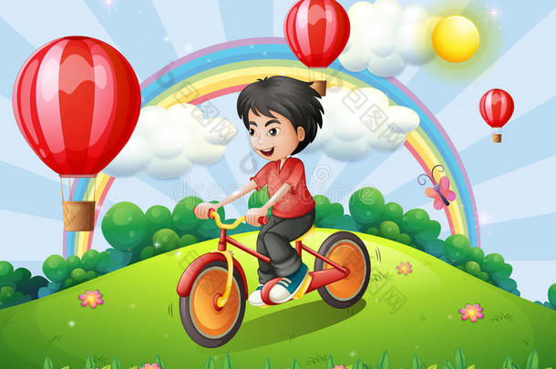 一个男孩骑着彩虹和<strong>漂浮</strong>的<strong>气球</strong>在山顶上骑车
