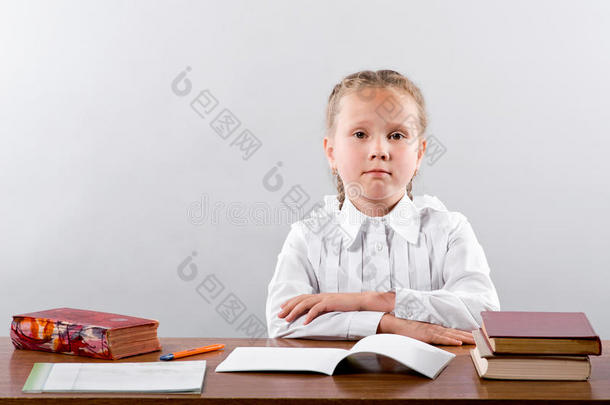 一个小女生坐在课桌旁