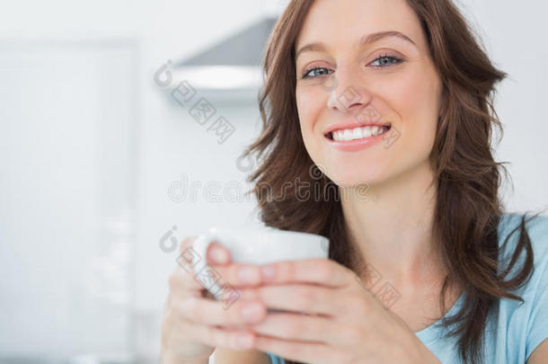 快乐的黑发女人端着一杯咖啡