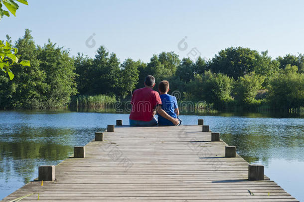 父子在池塘上的木墩上