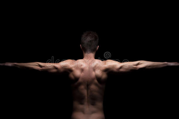 手臂伸展在黑色背景上的肌肉男