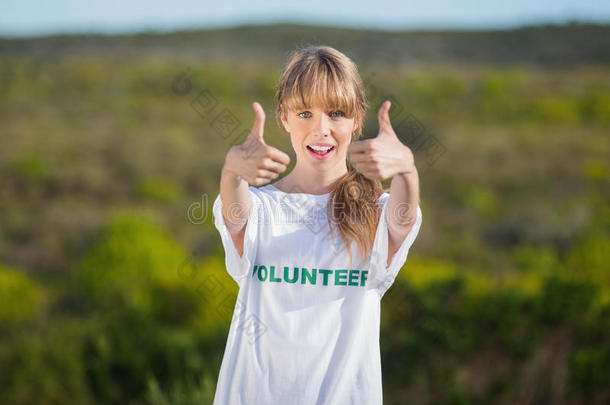 穿着志愿者t恤竖起大拇指的自然金发女郎