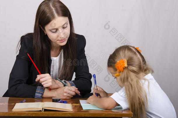 老师和一个坐在桌子旁的学生一起上课
