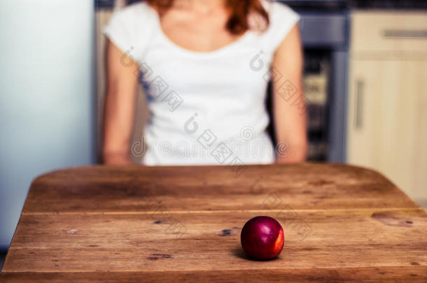 厨房里一个带着桃子的女人