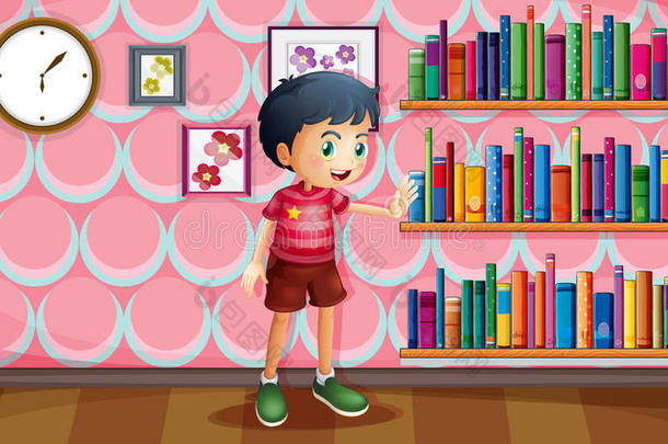 一个男孩站在书架旁拿着书