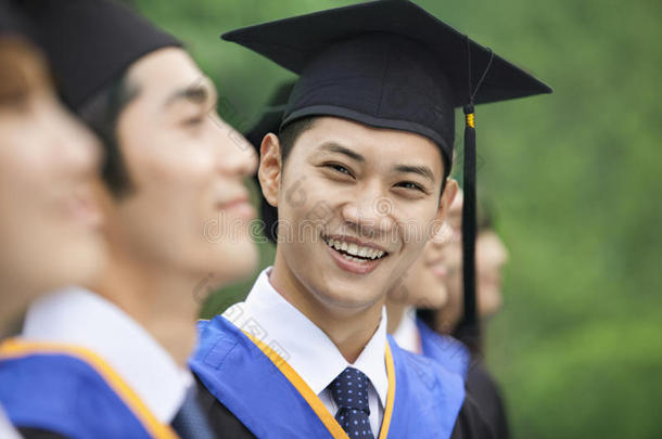 一排年轻的大学毕业生中微笑的年轻人