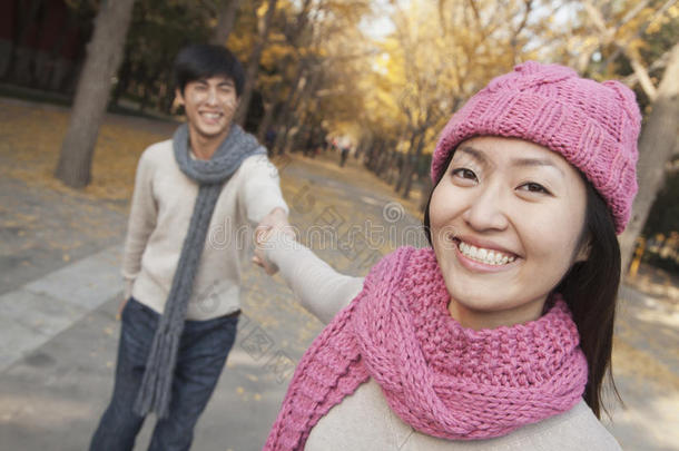 公园里一对手牵着手微笑的夫妇的画像