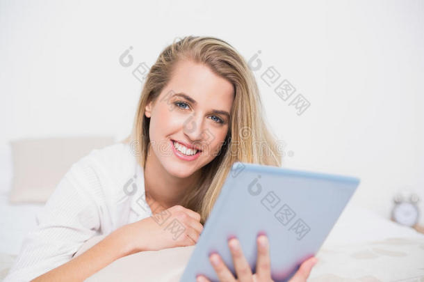 躺在舒适的床上用平板电脑微笑的美<strong>女模特</strong>