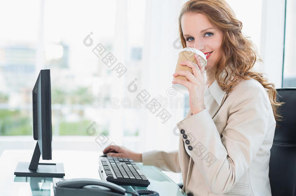 微笑着的漂亮女商人喝着咖啡