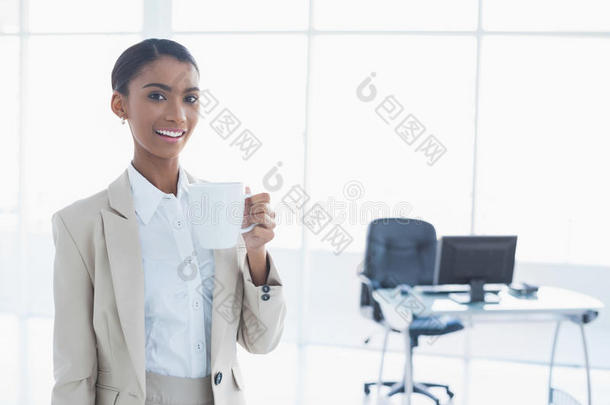 微笑优雅的女商人端着一杯咖啡