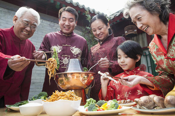 一家人穿着中式服装吃中餐