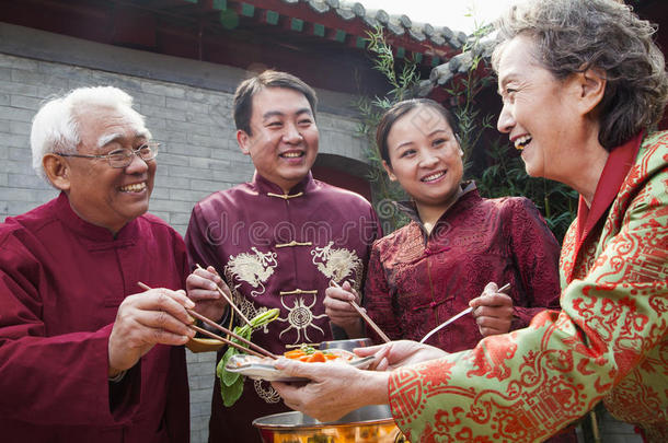 一家人穿着中式服装吃中餐