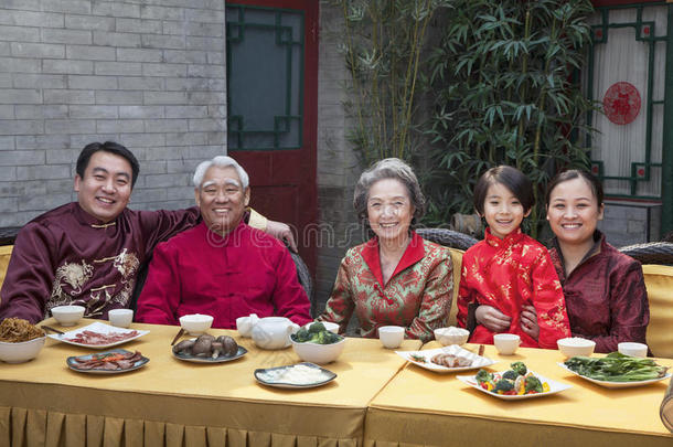 一家人穿着中式服装吃中餐的画像