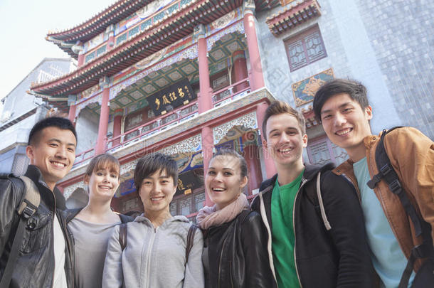 一群以中国建筑为背景的年轻人，画像。