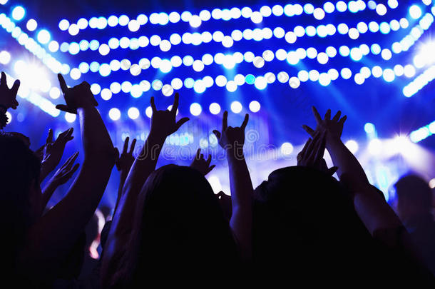 观众观看摇滚表演，手举在空中，后视图，<strong>舞台灯</strong>光