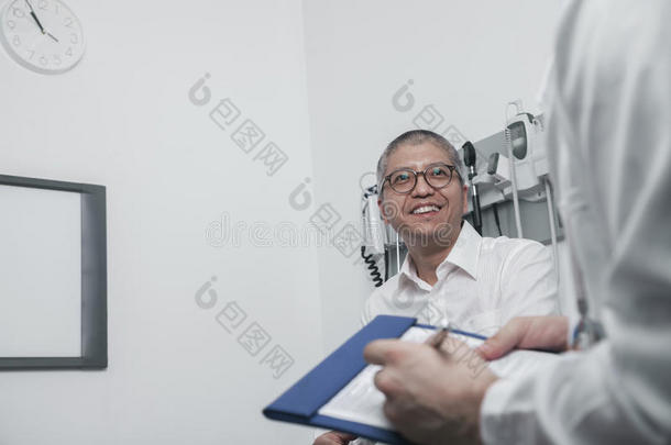 医生微笑着在病历上书写