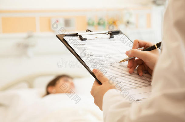 医生在病历上书写的特写镜头，病人躺在病床上