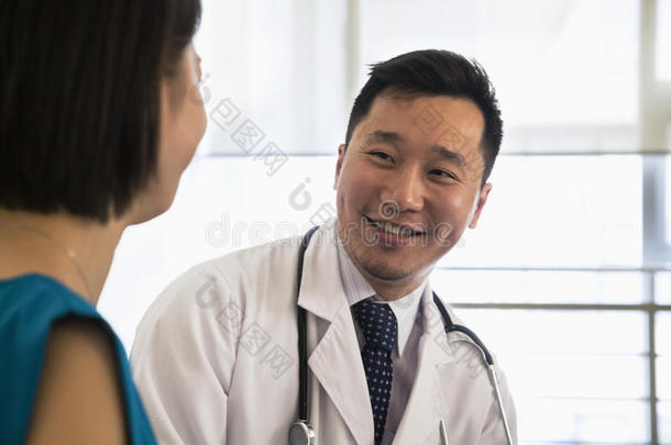 微笑的医生在医院里坐下来咨询病人，特写