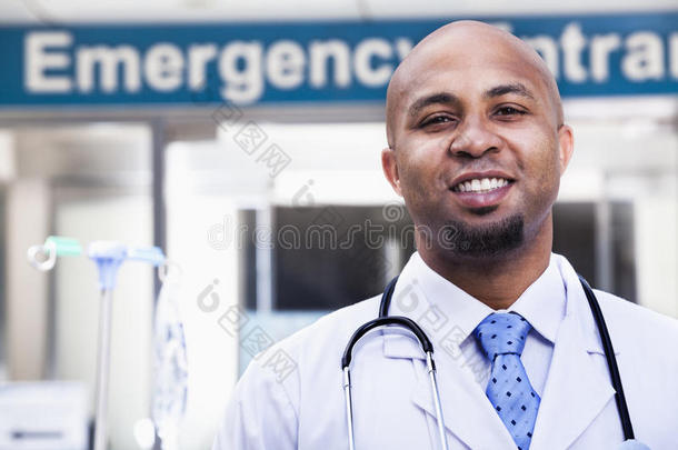 医院外微笑的医生画像，背景是急诊室标志