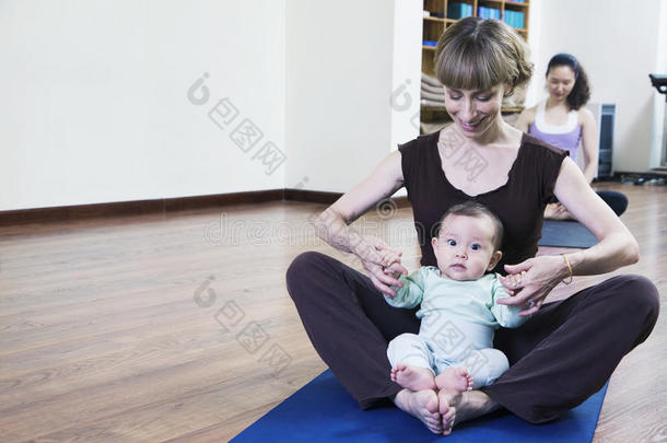 妈妈和宝宝<strong>盘腿坐</strong>在<strong>瑜伽</strong>课上练<strong>瑜伽</strong>
