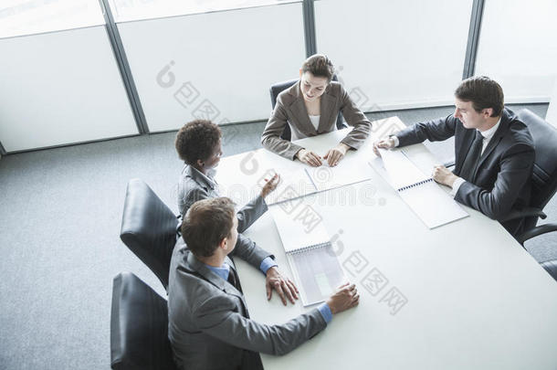 四个商务人士围坐在一张桌子旁，开商务会议，高角度观看