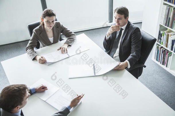 三个商务人士<strong>围坐</strong>在一张桌子旁，开商务会议，高角度观看