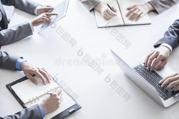 四个商务人士<strong>围坐</strong>在一张桌子旁，在商务会议期间，只手